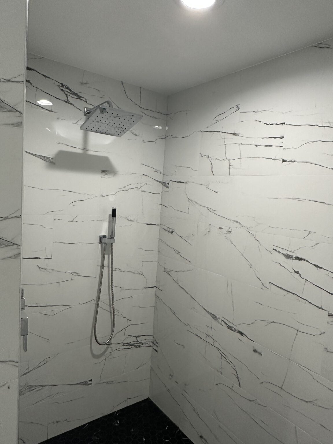 Marble walk-in shower with a rainfall shower head