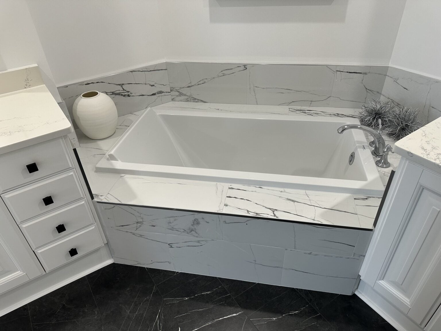 Remodeled bathroom with a freestanding soaking tub and marble surround