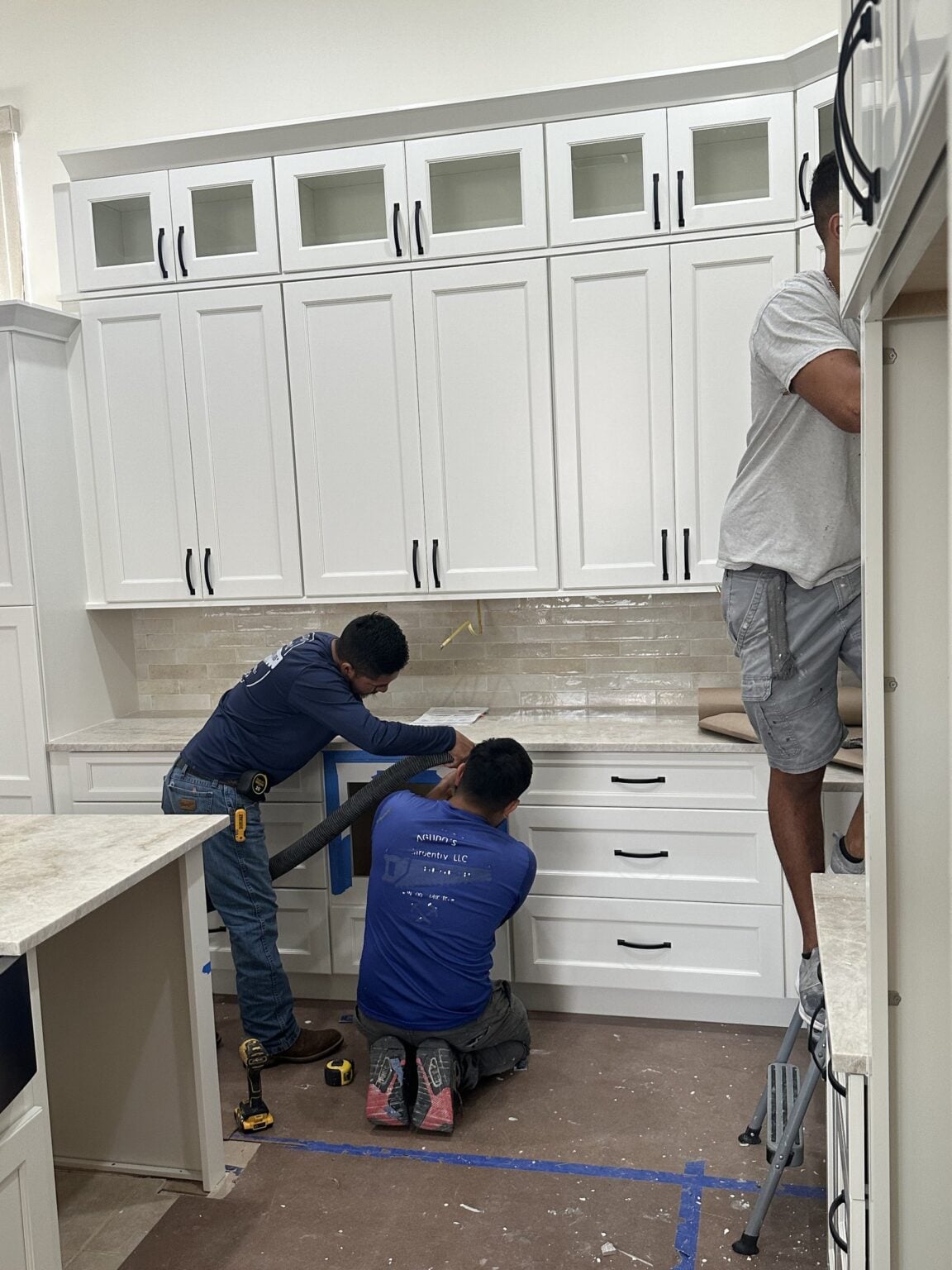 Complete Construction Group crew installing custom kitchen cabinetry in Bonita Springs
