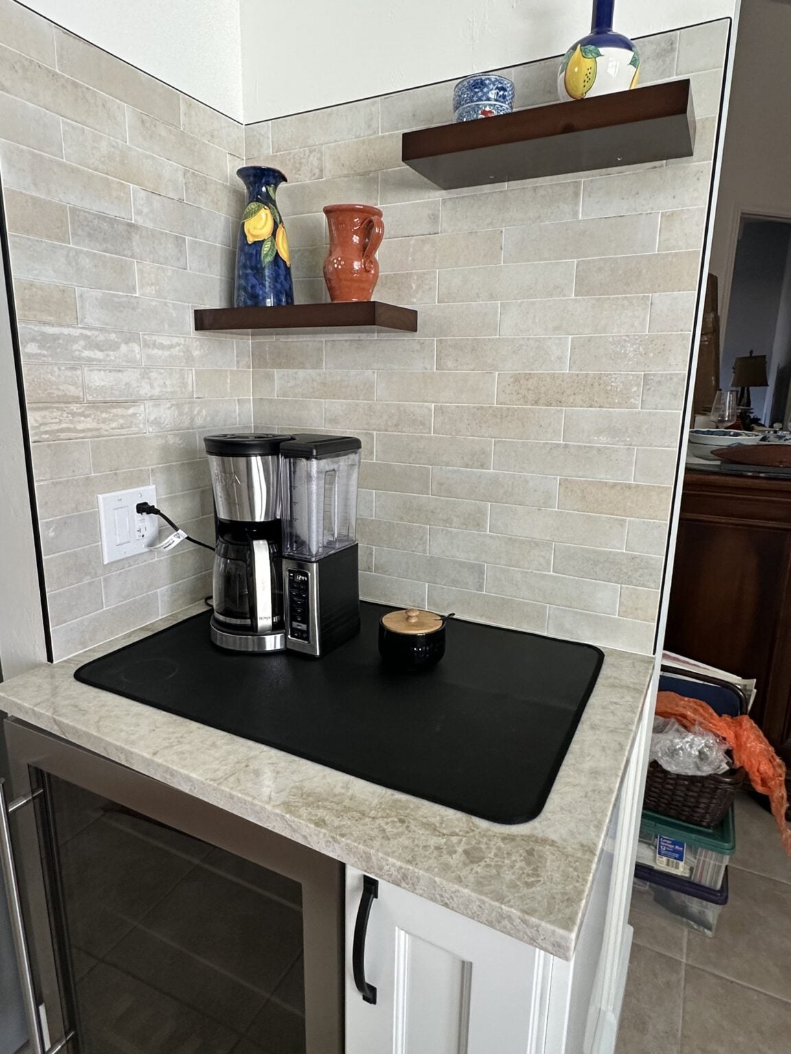 Custom floating wood shelves and coffee bar millwork on a stone feature wall