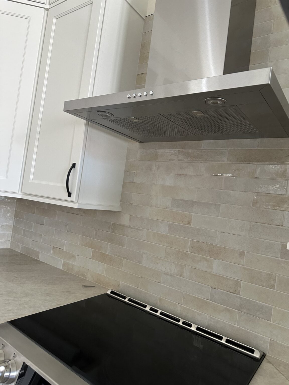 Custom range hood surround with travertine backsplash