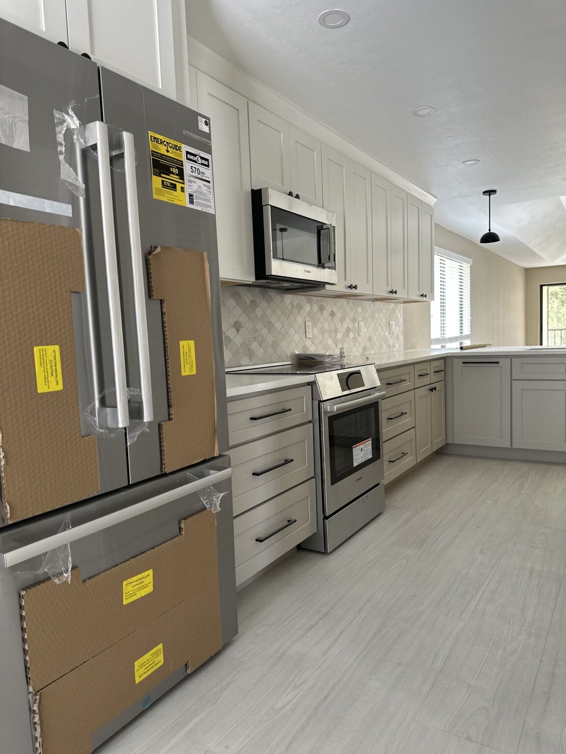 Remodeled kitchen with white shaker cabinetry and stainless appliances